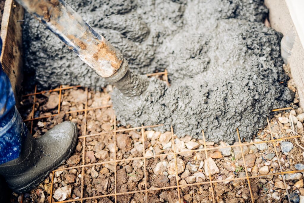 close up of construction workers using cement pump tube