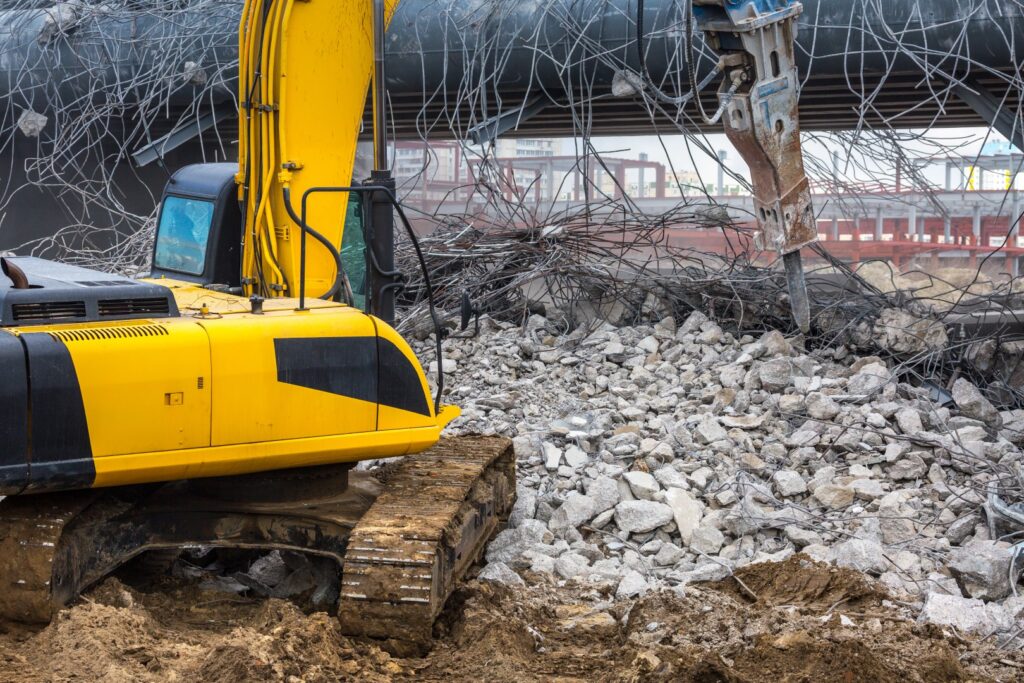 yellow excavator at construction site demolishing